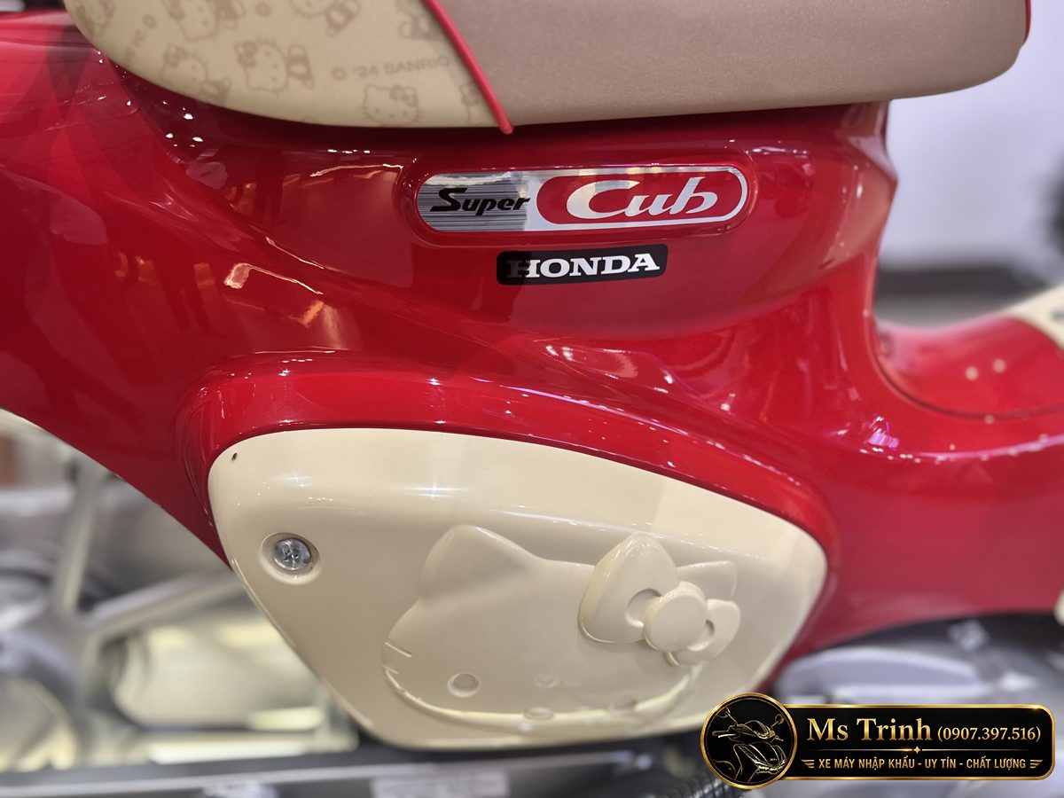Nắp hông phải màu kem có hình Hello Kitty và logo Honda Super Cub phía trên