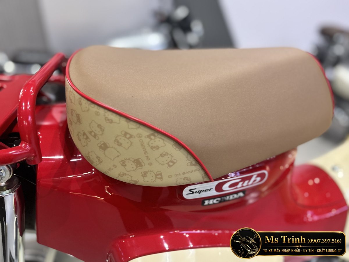 Yên Super Cub 110 Hello Kitty màu sáng với viền đỏ và họa tiết nhân vật bên hông