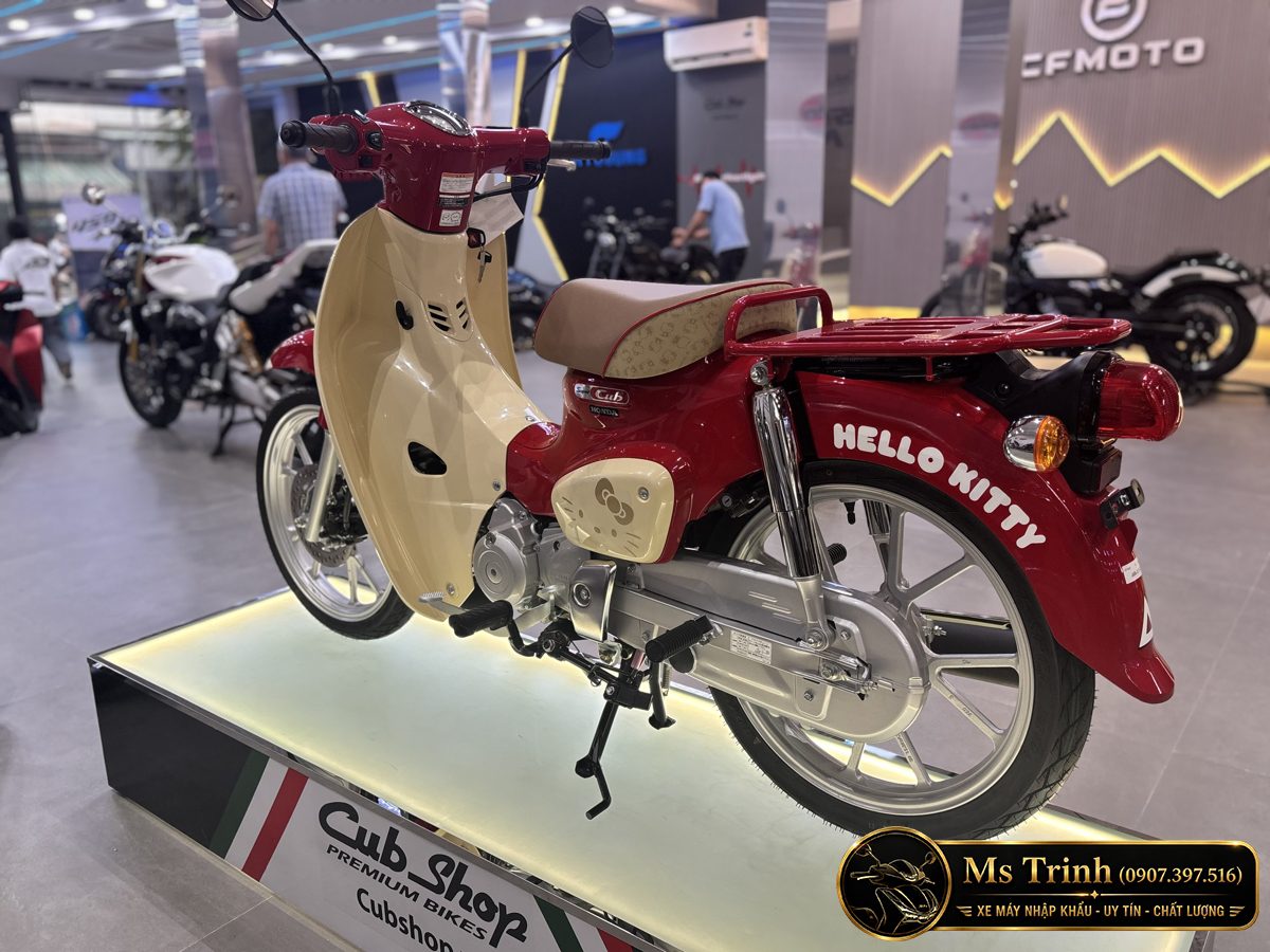 Honda Super Cub 110 Hello Kitty nhìn từ phía sau bên trái với baga đỏ đồng bộ